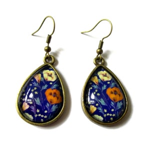 PENDIENTES COLGANTES, pendientes colgantes, patrones de flores silvestres, joyas de flores multicolores, fondo azul, rústico, moderno