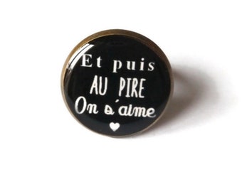 Puede incluir: Un anillo negro con una inscripción blanca que dice "Et puis au pire On s'aime" con un pequeño corazón blanco.