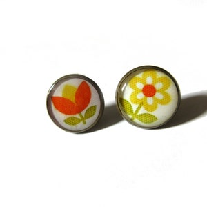 May include: A pair of earrings with a flower design. One earring features a yellow flower with a red center, and the other earring features a red flower with a yellow center.