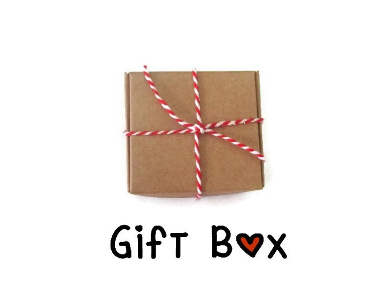May include: A brown cardboard gift box tied with red and white twine. The box is sitting on a white background. The text "Gift Box" is written below the box with a red heart symbol.