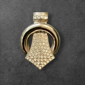 May include: A silver pendant with a large, diamond-shaped crystal surrounded by a circle of smaller crystals. The pendant is attached to a silver chain.