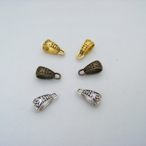 May include: Five ornate metal pendant bails in three different finishes: gold, bronze, and silver. Each bail has a decorative floral design.
