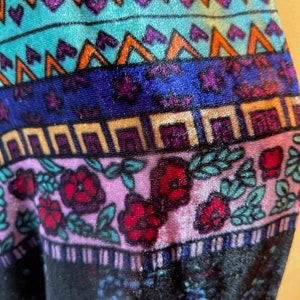 Puede incluir: Primer plano de una tela colorida con un patr&oacute;n geom&eacute;trico y dise&ntilde;o floral. La tela es de terciopelo y tiene un tacto suave y lujoso.