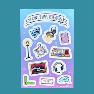 Puede incluir: Una hoja de pegatinas con varias ilustraciones temáticas de teatro. Los diseños incluyen máscaras de drama, un foco, un guion, un escenario, un boleto y el texto "I CAN'T, I HAVE REHEARSAL". El fondo tiene un degradado de azul y morado.