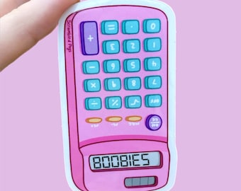 May include: A pink calculator sticker with teal buttons and a purple plus sign. The digital display shows the text 80081ES in black. The brand name Scrambled Pegs is printed vertically in small black letters along the left side of the calculator.
