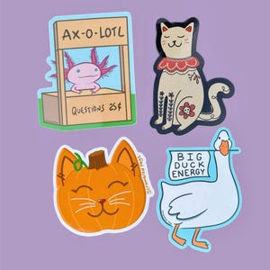 May include: Four colorful stickers on a purple background. The stickers feature an axolotl at a stand with the text "AX-O-LOTL" and "QUESTIONS 25¢", a cat with floral details, a pumpkin with a cat face, and a duck with a sign that says "BIG DUCK ENERGY".