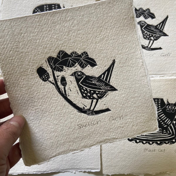 Shelter, handmade linocut featuring little bird and acorns.