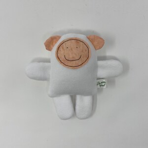May include: White plush toy shaped like a sheep with a brown felt face and a smiling mouth. The toy has a small tag that says "Love you"