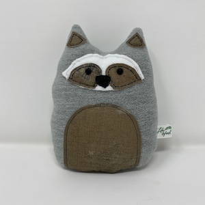 May include: Gray plush raccoon stuffed animal with black eyes, a white nose, and brown ears. The raccoon has a brown belly patch and a small tag that says "Lily & Jack".