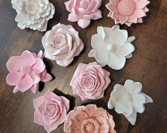 May include: Assortment of pink and white floral decorations. The flowers are made of plaster and have a smooth, matte finish. They are perfect for adding a touch of elegance to any home decor.