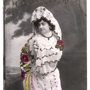 Pode incluir: Fotografia vintage em preto e branco de uma mulher com um vestido tradicional espanhol. O vestido é branco com renda e detalhes florais. A imagem tem texto na parte superior que diz "ILesita Arcia" e "Filomena".