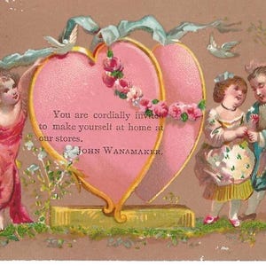 May include: Vintage Valentine's Day card featuring a pink heart-shaped frame with floral accents and the text "You are cordially invited to make yourself at home at our stores. JOHN WANAMAKER." A cherub and two children are also depicted.
