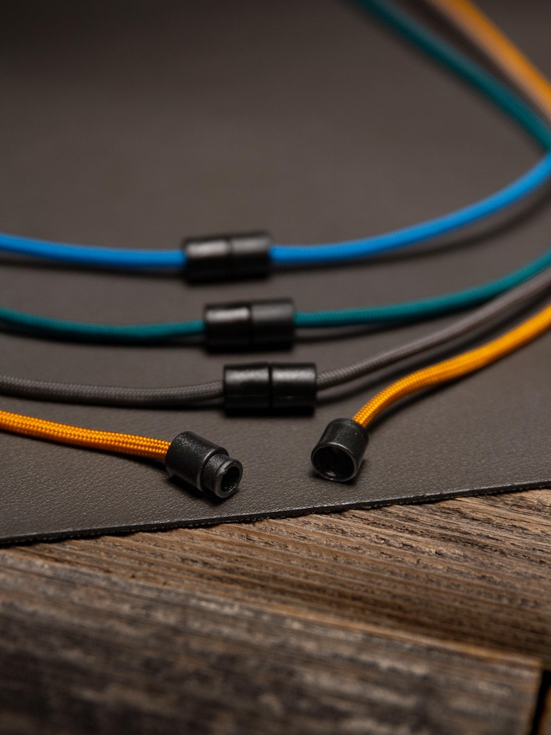 Back view of Paracord ID Lanyards showing durable breakaway safety clasps and color-matched cords in Goldenrod, Charcoal Grey, Teal, and Caribbean Blue — lightweight and non-metal for MRI environments.