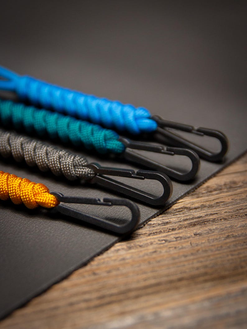 Close-up angled view of Paracord ID Lanyards showing black non-ferrous clips and braided paracord detail, emphasizing the rugged design of the MRI-safe badge holders.