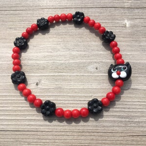 Kattenarmband met zwarte glazen bloemen en 4 mm geverfde rode bambo-koraalkralen