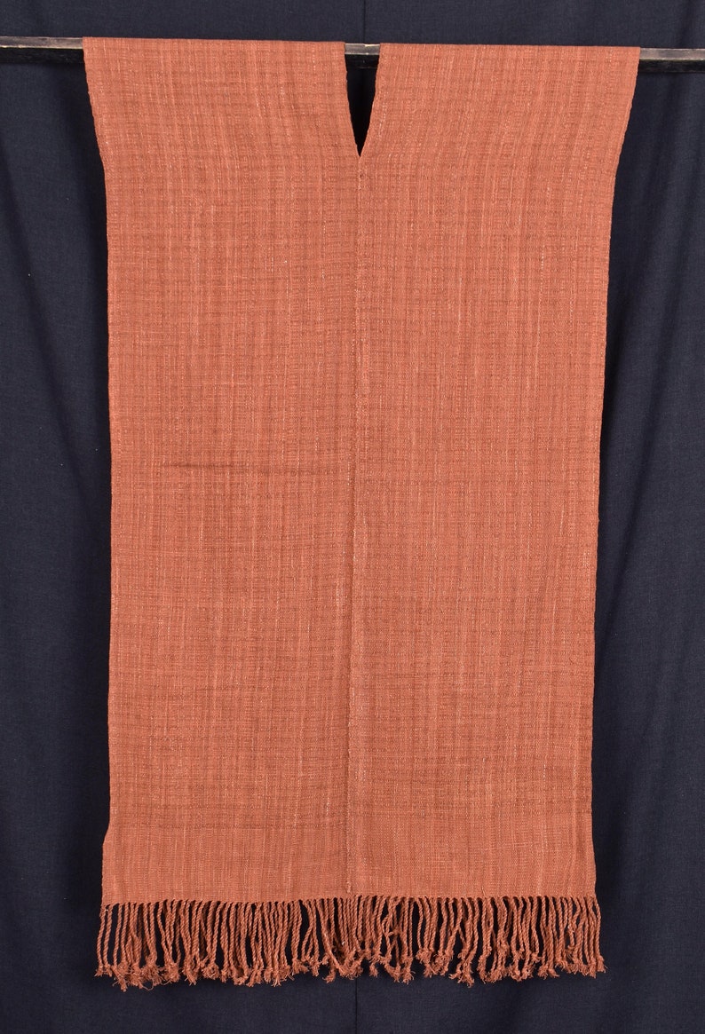 Peut inclure: Une &eacute;charpe tiss&eacute;e de couleur rouille avec un col en V et une bordure &agrave; franges.
