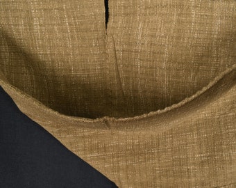 Peut inclure: Gros plan sur un tissu brun à armure texturée. Le tissu est plié en deux, créant un V.