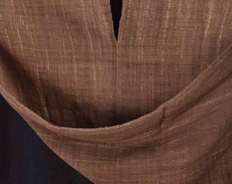 Peut inclure: Gros plan sur un tissu brun avec un léger brillant. Le tissu est plié en deux, créant un V en haut. Le tissu a une apparence texturée et tissée.