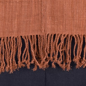 Peut inclure: Un textile tiss&eacute; brun avec une bordure &agrave; franges. Les franges sont faites de brins torsad&eacute;s du m&ecirc;me mat&eacute;riau que le textile.
