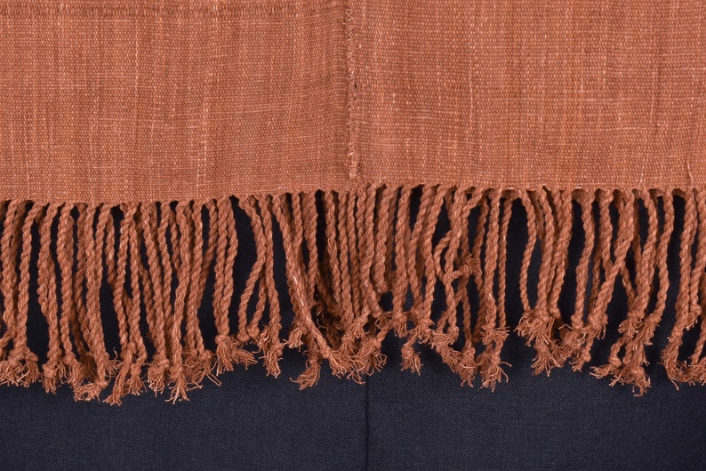 Peut inclure: Un textile tiss&eacute; brun avec une bordure &agrave; franges. Les franges sont faites de brins torsad&eacute;s du m&ecirc;me mat&eacute;riau que le textile.