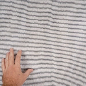 Peut inclure: Gros plan sur un tissu blanc &agrave; fines rayures bleu fonc&eacute;. Le tissu a une surface l&eacute;g&egrave;rement textur&eacute;e.