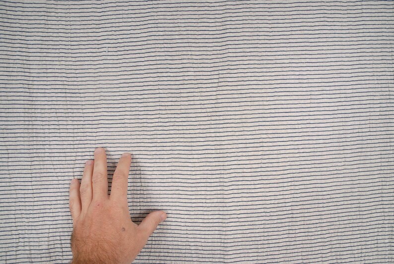 Peut inclure: Gros plan sur un tissu blanc &agrave; fines rayures bleu fonc&eacute;. Le tissu a une surface l&eacute;g&egrave;rement textur&eacute;e.