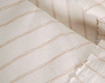 Tejido de algodón resistente de color blanco roto, con rayas tejidas en tono tostado, fabricado en telar tailandés.