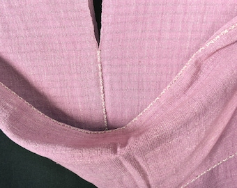 Peut inclure: Gros plan sur un tissu rose avec des coutures blanches. Le tissu est plié en deux et les coutures sont visibles des deux côtés.