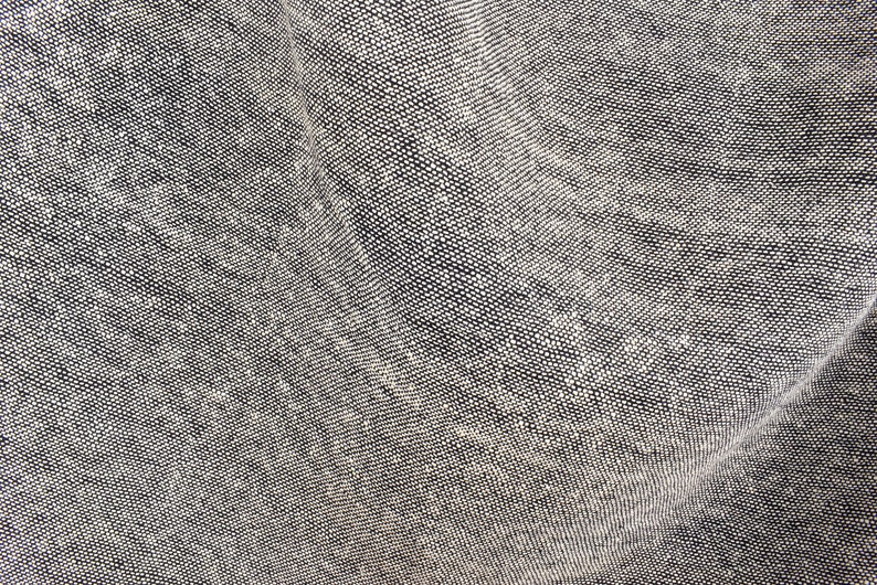 Puede incluir: Primer plano de una tela gris tejida con una superficie texturizada.