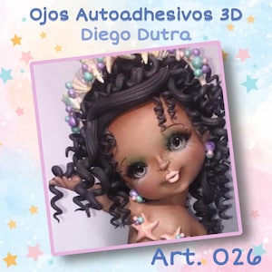 May include: A close-up of a doll's face with brown skin, large eyes, and curly black hair. The doll is wearing a seashell crown and a necklace of beads. The doll's lips are painted pink. The image is surrounded by a pink and blue background with stars.