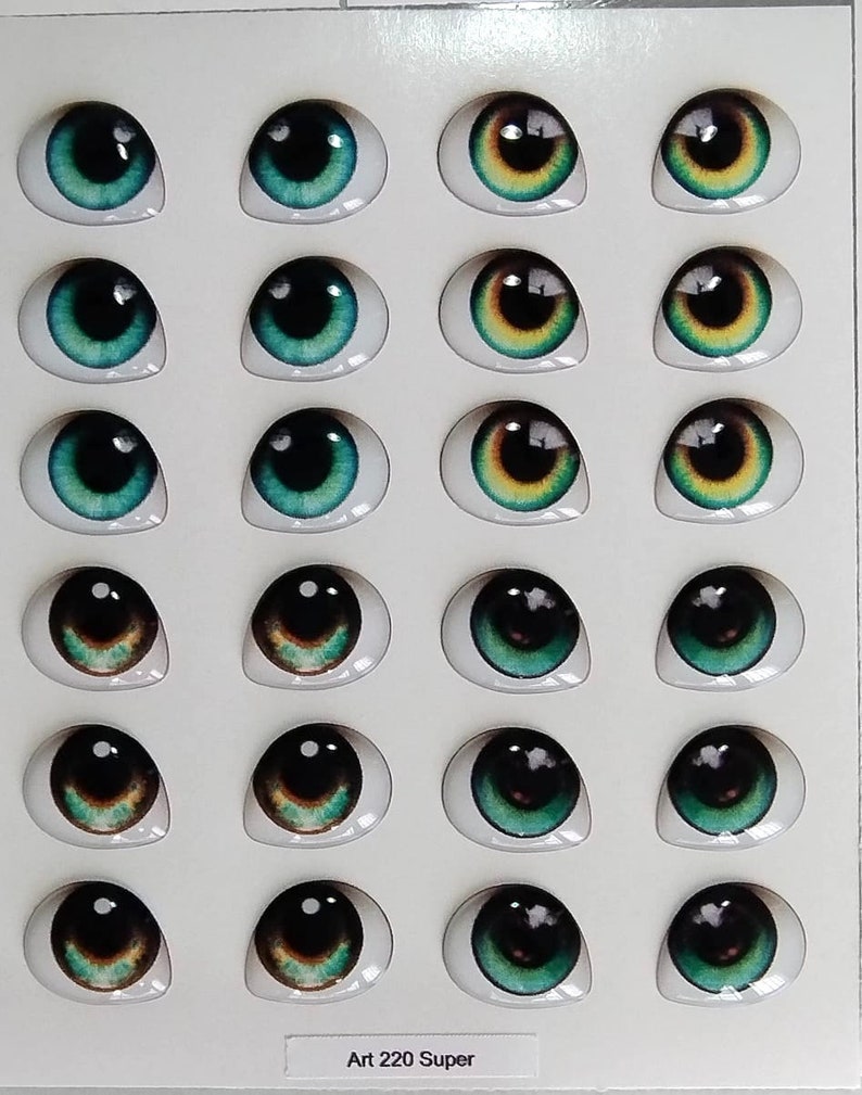 May include: A sheet of 20 doll eyes, with a variety of colors and designs. The eyes are arranged in four rows of five. The eyes are all oval shaped and have a black pupil. The colors of the eyes include green, brown, and yellow. The sheet is labeled "Art 220 Super".