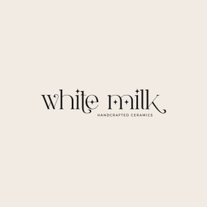 Op de afbeelding: White Milk logo met een gestileerd lettertype en kleine sterren. De tekst onder het logo luidt "Handgemaakte keramiek".