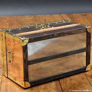 May include: A wooden and copper travel trunk with brass accents and a hinged lid. The trunk has two compartments and a brass latch.