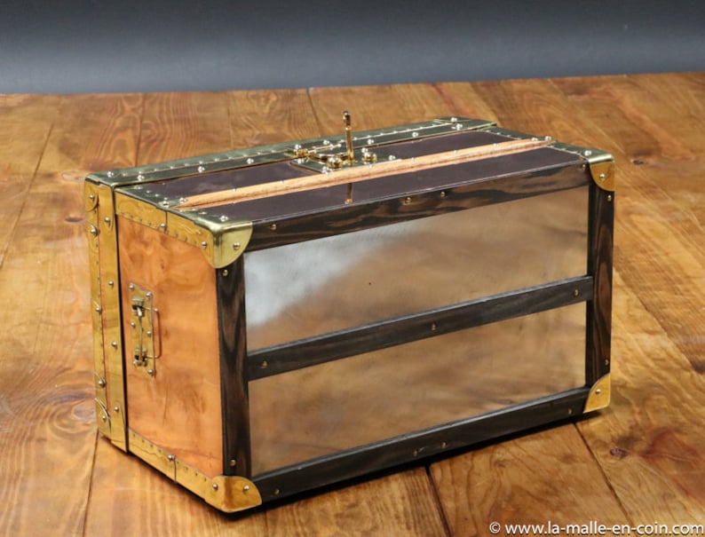 May include: A wooden and copper travel trunk with brass accents and a hinged lid. The trunk has two compartments and a brass latch.