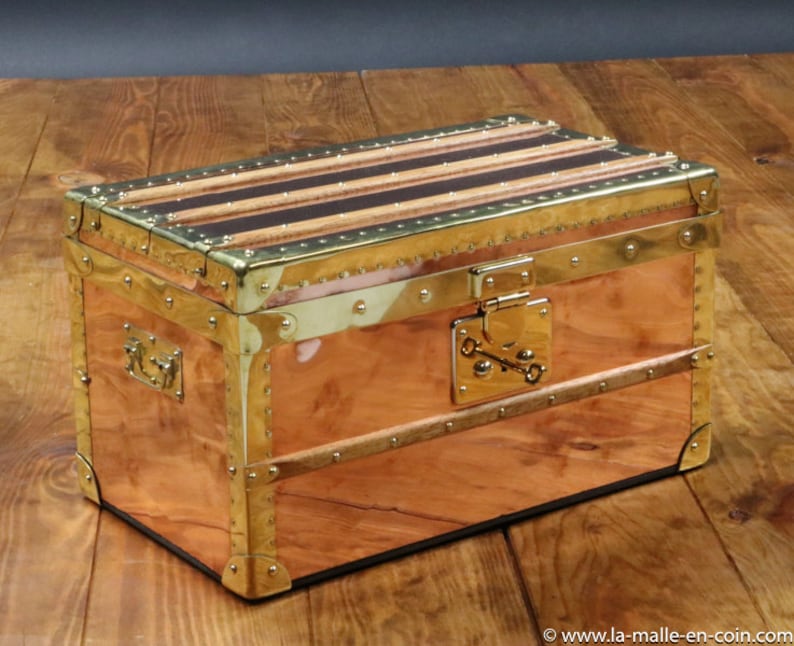 May include: A vintage copper and brass travel trunk with a leather top and brass hardware. The trunk has a lock with a key and is decorated with brass studs.