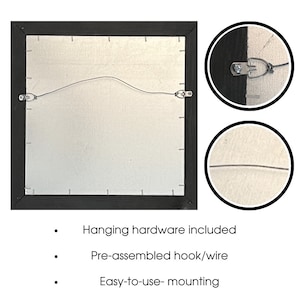 May include: Back of a framed artwork with a black frame, silver backing, and pre-installed hanging hardware. The image shows a wire and hooks for easy wall mounting. Text on the image states "Hanging hardware included", "Pre-assembled hook/wire", and "Easy-to-use- mounting".