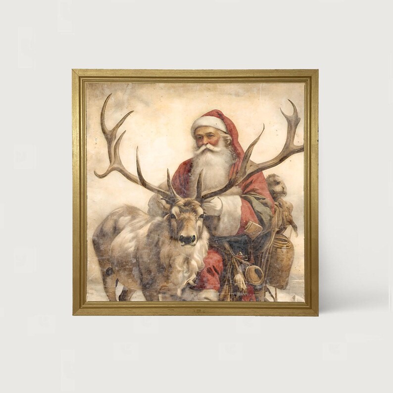May include: A framed vintage Christmas print featuring Santa Claus in a red suit and hat, with a long white beard, seated next to a reindeer with large antlers. The print has a gold frame and a faded, antique appearance.