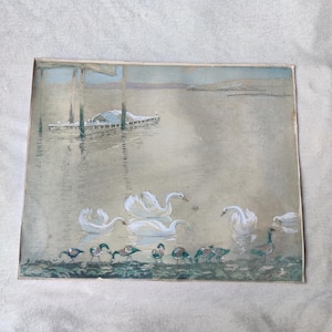 May include: A rectangular print featuring a muted landscape scene with a calm body of water. Several white swans swim in the center, while a group of small ducks stands along the grassy shoreline. A wooden pier structure is visible in the distance.