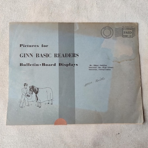 May include: Vintage envelope for "Pictures for Ginn Basic Readers Bulletin-Board Displays." The envelope is light blue with text and a drawing of a person with a horse. Includes a New York postage stamp and the text "PAID PERMIT 102."