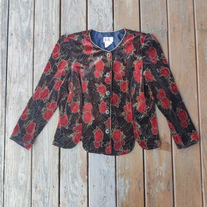 May include: A brown velvet blazer with a red floral pattern and gold accents. The long-sleeved jacket has a round neckline and is buttoned down the front. The tag reads "RK".