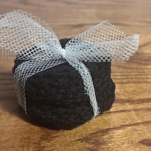 May include: A black fabric gift box wrapped with a white tulle ribbon.