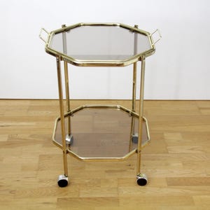 Vintage achthoekige serveerwagen voor de bar // 2 lagen, goudkleurig metalen frame met afneembaar dienblad van rookglas, jaren 80