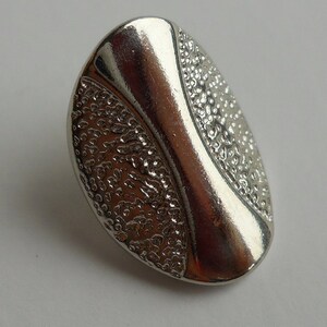 BUTTON SET: Better buttons, silver, texture on upper surface, 1/2&quot; x 3/4&quot; size, set of 9 buttons.