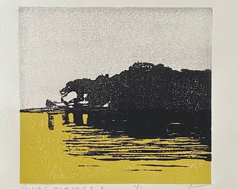 May include: A black and white print of a landscape with a dark silhouette of a rocky island in the foreground and a light gray sky in the background. The water is depicted in a light yellow color. The print is titled "Quiet Waters 2".