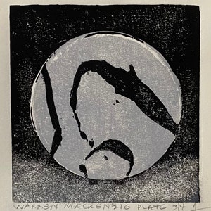 May include: A black and white abstract print with a gray circle in the center. The circle has black lines and shapes inside. The print is signed "WARREN MACKENZIE PLATE 314".