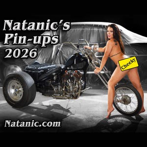 May include: A black trike motorcycle with a woman standing next to it. The woman is wearing a black bikini top and a yellow sticker that says "Cheeky" on her backside. The motorcycle has a black leather seat and a chrome exhaust pipe. The background is a gray garage with a car covered in a white sheet.
