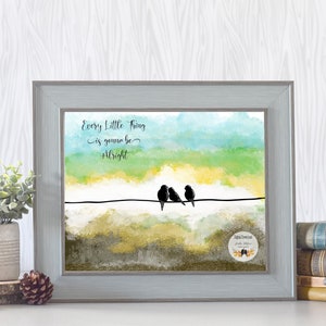 May include: A watercolor painting of a sunset with three birds perched on a wire. The text "Every little thing is gonna be alright" is written in black cursive above the birds. The painting is framed in a light gray frame.