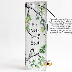 wood wall art featuring a sweet chickadee bird sitting on a tree branch with leaves that are shades of green and yellow, another branch hangs from above perfectly framing the comforting phrase It is Well with my Soul