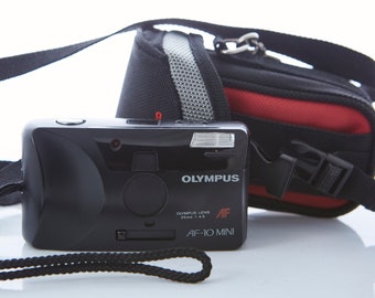 Appareil photo argentique Olympus AF-10 Mini. Appareil photo argentique 35 mm Olympus. Caméra pointée et prise de vue. Caméra de travail.