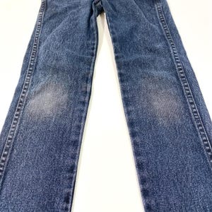 Może przedstawiać: Dżinsy z niebieskiego denimu o prostym kroju nogawek. Dżinsy mają wyblakły wygląd i są wykonane z miękkiego, wygodnego materiału.